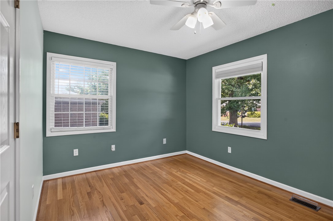 113 Greenfield Avenue Pendleton, SC 29670 - Photo 18 of 40 Wood flooring and ample natural light define this cozy bedroom space.