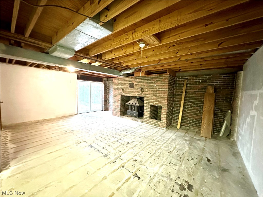 2039 St Johns Road Colliers, WV 26035 - Photo 23 of 35 Basement featuring a wood stove, brick wall, and a fireplace