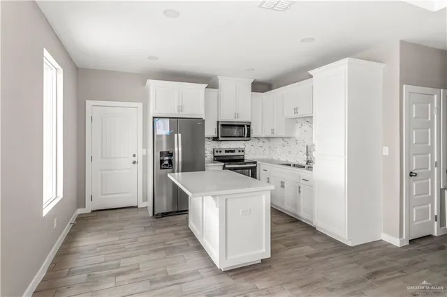a kitchen with white cabinets stainless steel appliances and sink