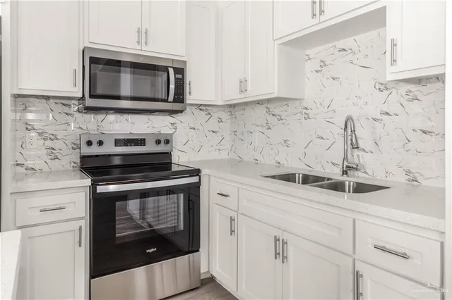 a kitchen with a sink appliances and cabinets