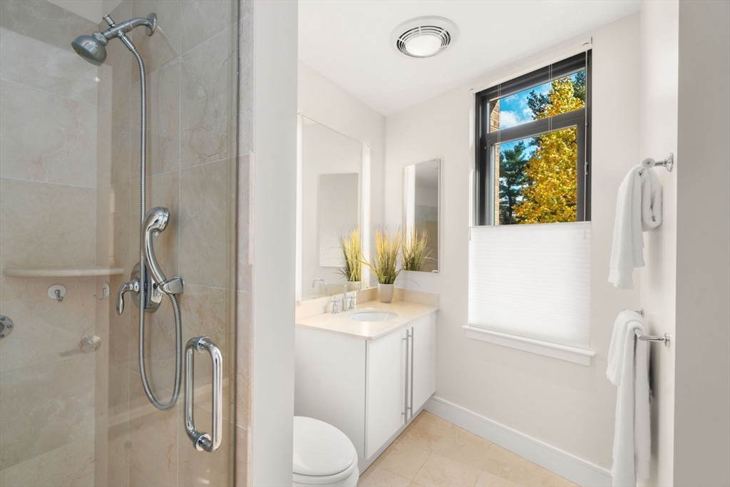 2400 Beacon Street, Unit 112 Boston, MA 02467 - Photo 14 of 21 a bathroom with a granite countertop sink toilet and shower