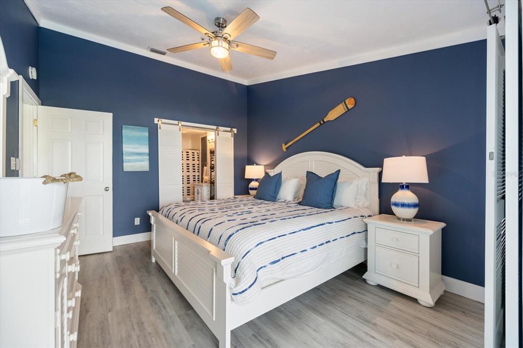 841 Waterside Drive, Unit 202 Venice, FL 34285 - Photo 27 of 43 a bedroom with a bed and a chandelier