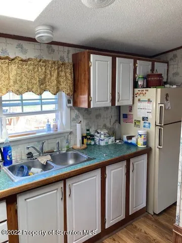 a kitchen with stainless steel appliances granite countertop a sink window and cabinets