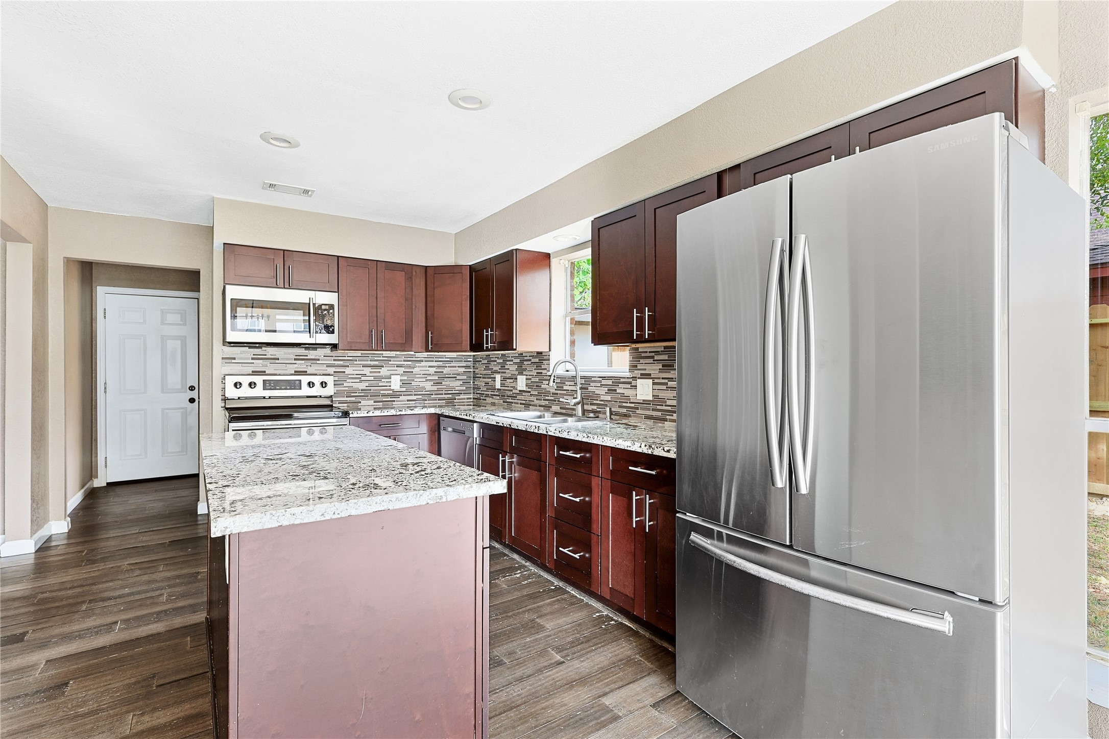 11727 Gardenglen Drive Cypress, TX 77429 - Photo 13 of 38 a kitchen with stainless steel appliances granite countertop a refrigerator and a sink