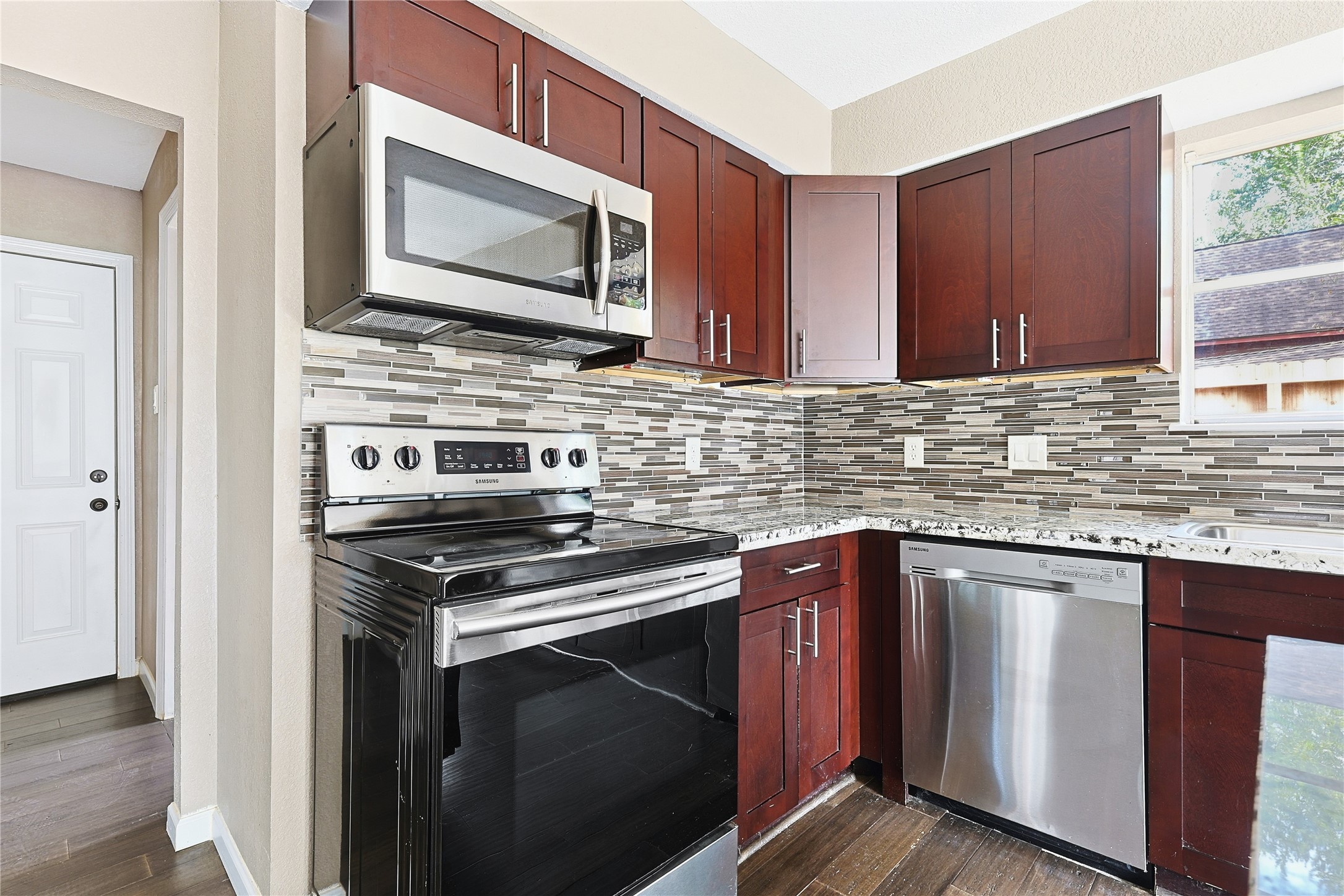 11727 Gardenglen Drive Cypress, TX 77429 - Photo 14 of 38 a kitchen with stainless steel appliances granite countertop a stove microwave and sink