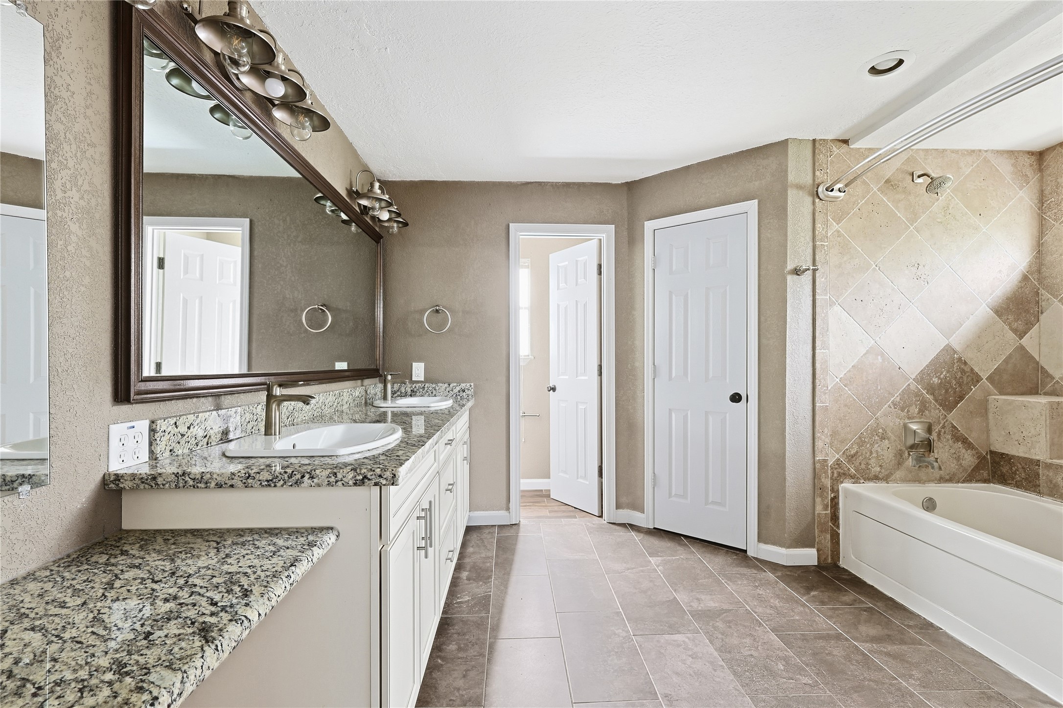 11727 Gardenglen Drive Cypress, TX 77429 - Photo 21 of 38 a en suite bathroom with a double vanity sink a mirror and a bathtub
