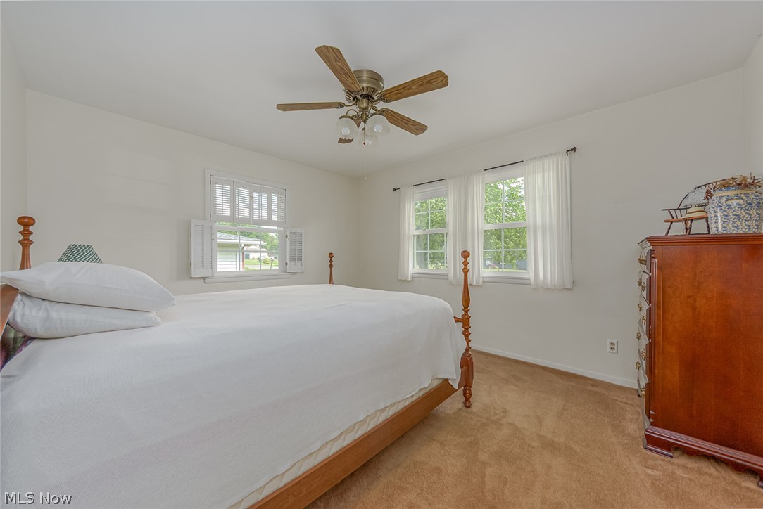 3331 Boyne Road Barberton, OH 44203 - Photo 8 of 22 The bedroom features a ceiling fan, sliding doors to the closet, and hardwood floors under the carpet.
