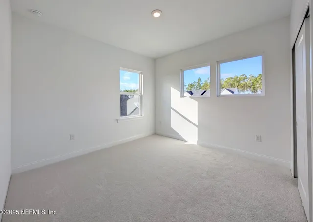 an empty room with windows and mirror