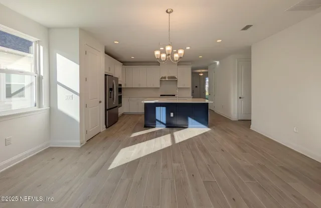 a view of a kitchen with a sink and dishwasher cabinet with wooden floor
