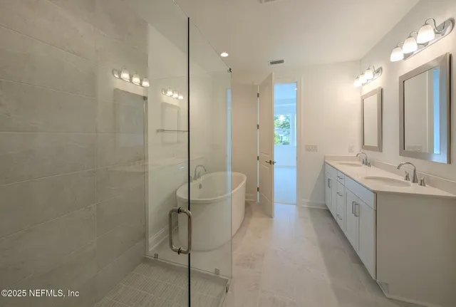 a bathroom with a double vanity sink a toilet and shower