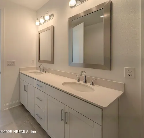 a bathroom with double sink and a mirror