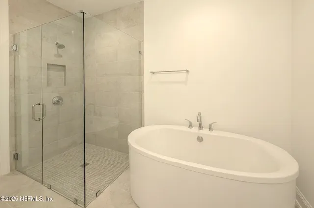 a white bath tub sitting next to a shower