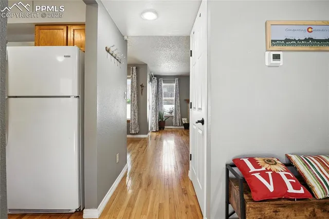 a view of a hallway with wooden floor and cabinet