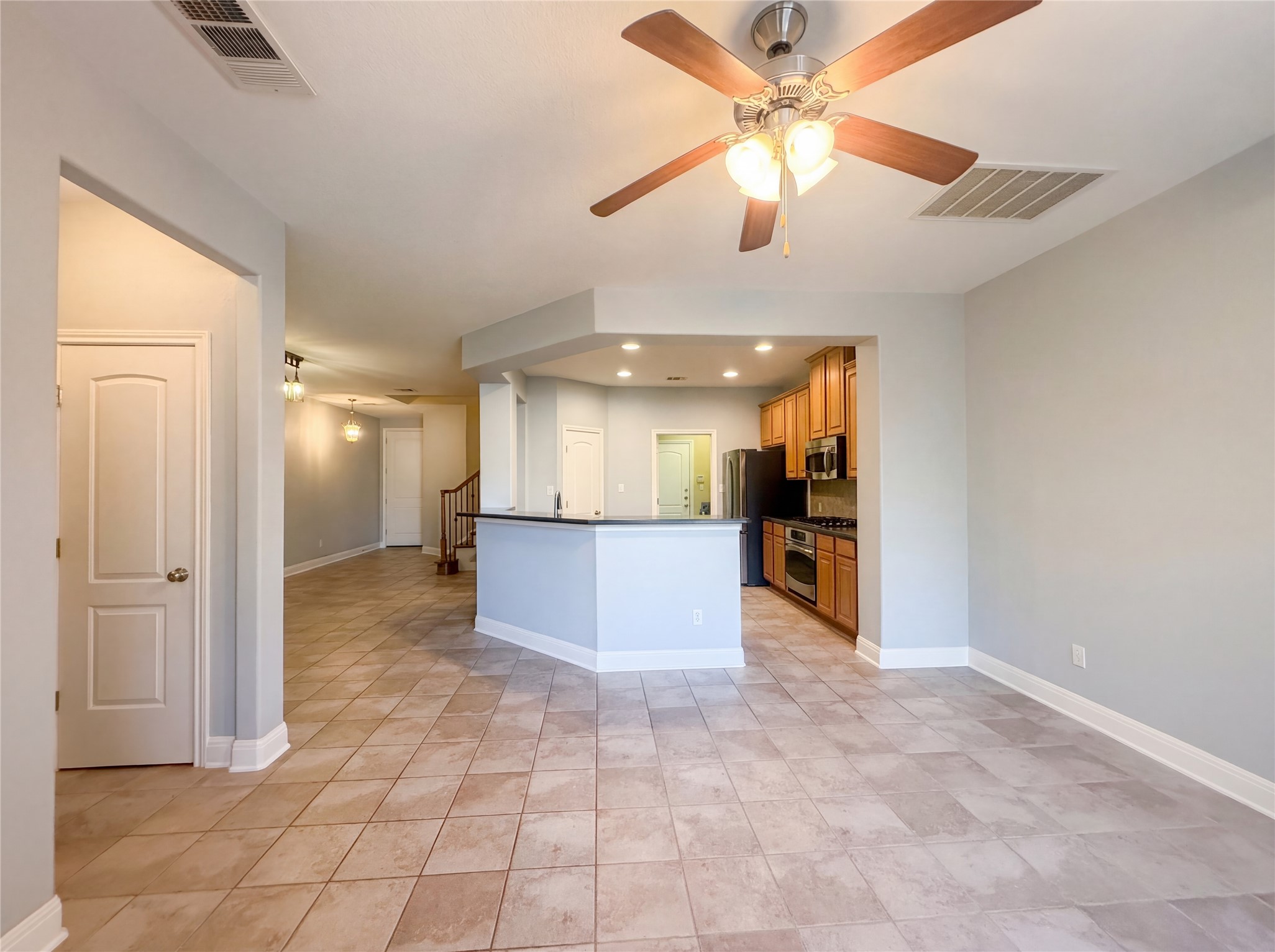 104 Perpetuation Drive Austin, TX 78734 - Photo 29 of 29 Kitchen featuring dark countertops, a ceiling fan, open floor plan, wood finish cabinetry, and recessed lighting