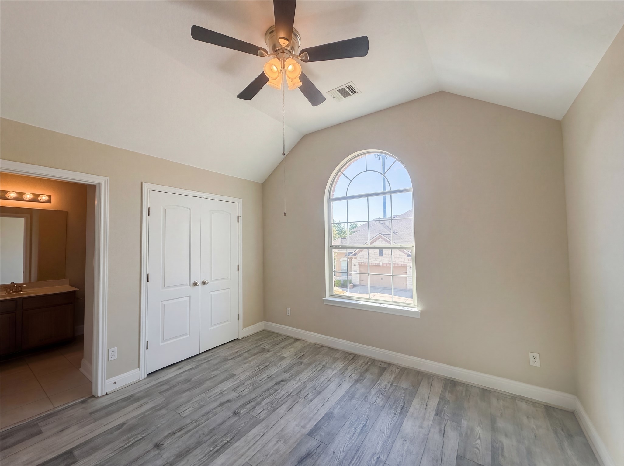 104 Perpetuation Drive Austin, TX 78734 - Photo 15 of 29 Unfurnished bedroom featuring a ceiling fan, a closet, light wood finished floors, and ensuite bath