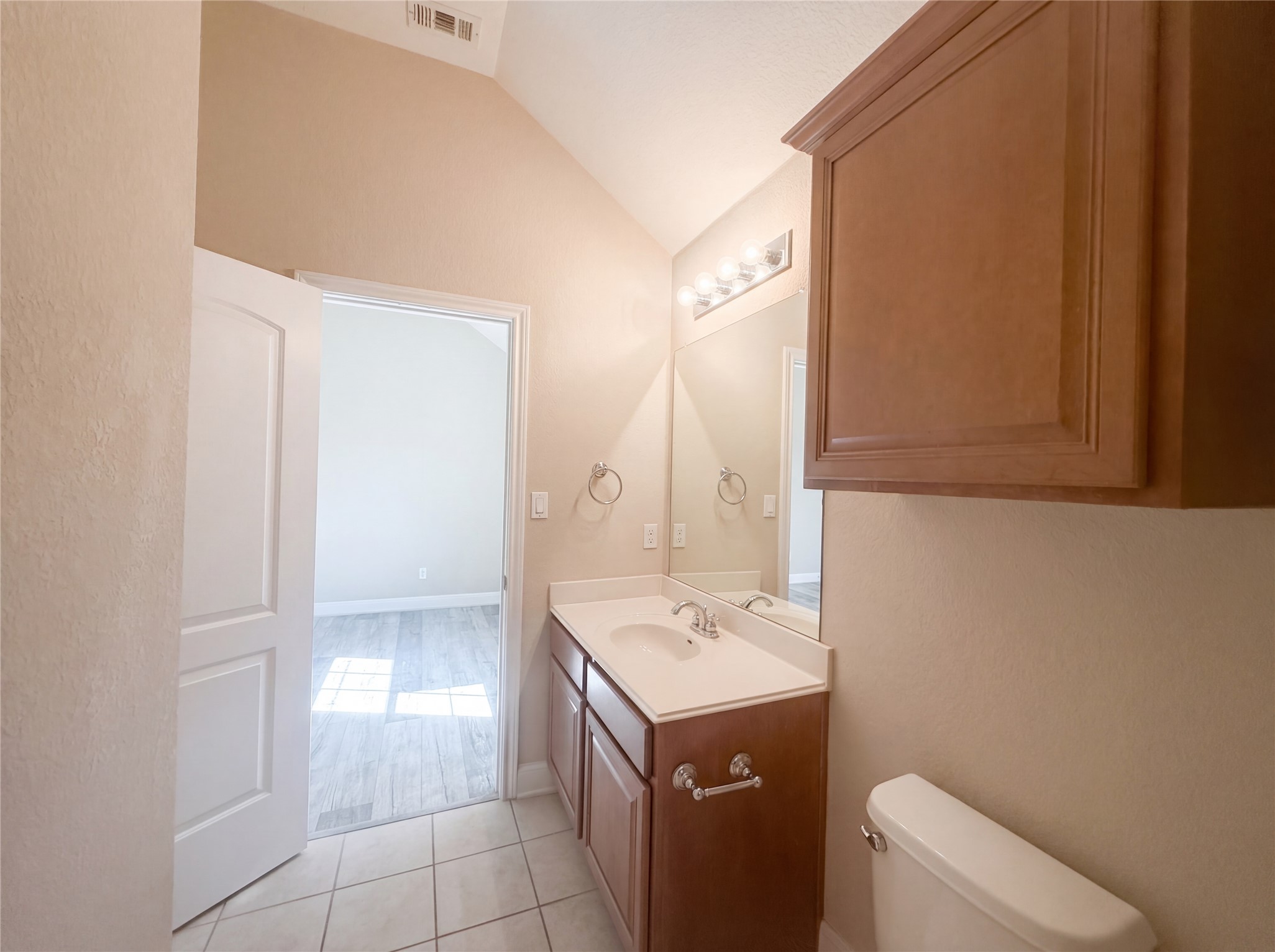 104 Perpetuation Drive Austin, TX 78734 - Photo 18 of 29 Half bath featuring vanity, lofted ceiling, and light tile patterned floors