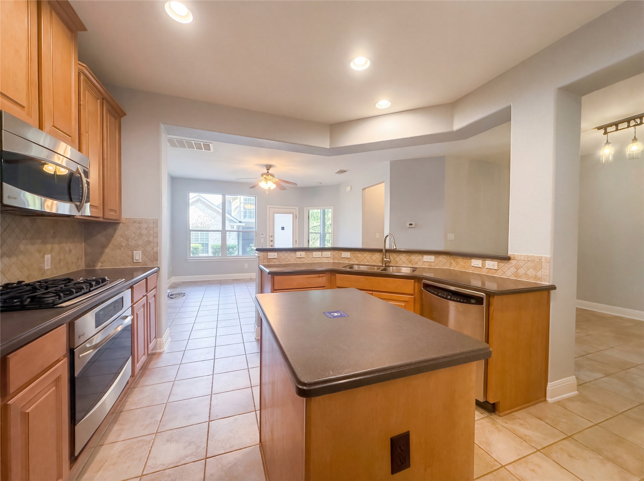 104 Perpetuation Drive Austin, TX 78734 - Photo 2 of 29 Kitchen featuring backsplash, light tile patterned floors, stainless steel appliances, a kitchen island, and recessed lighting
