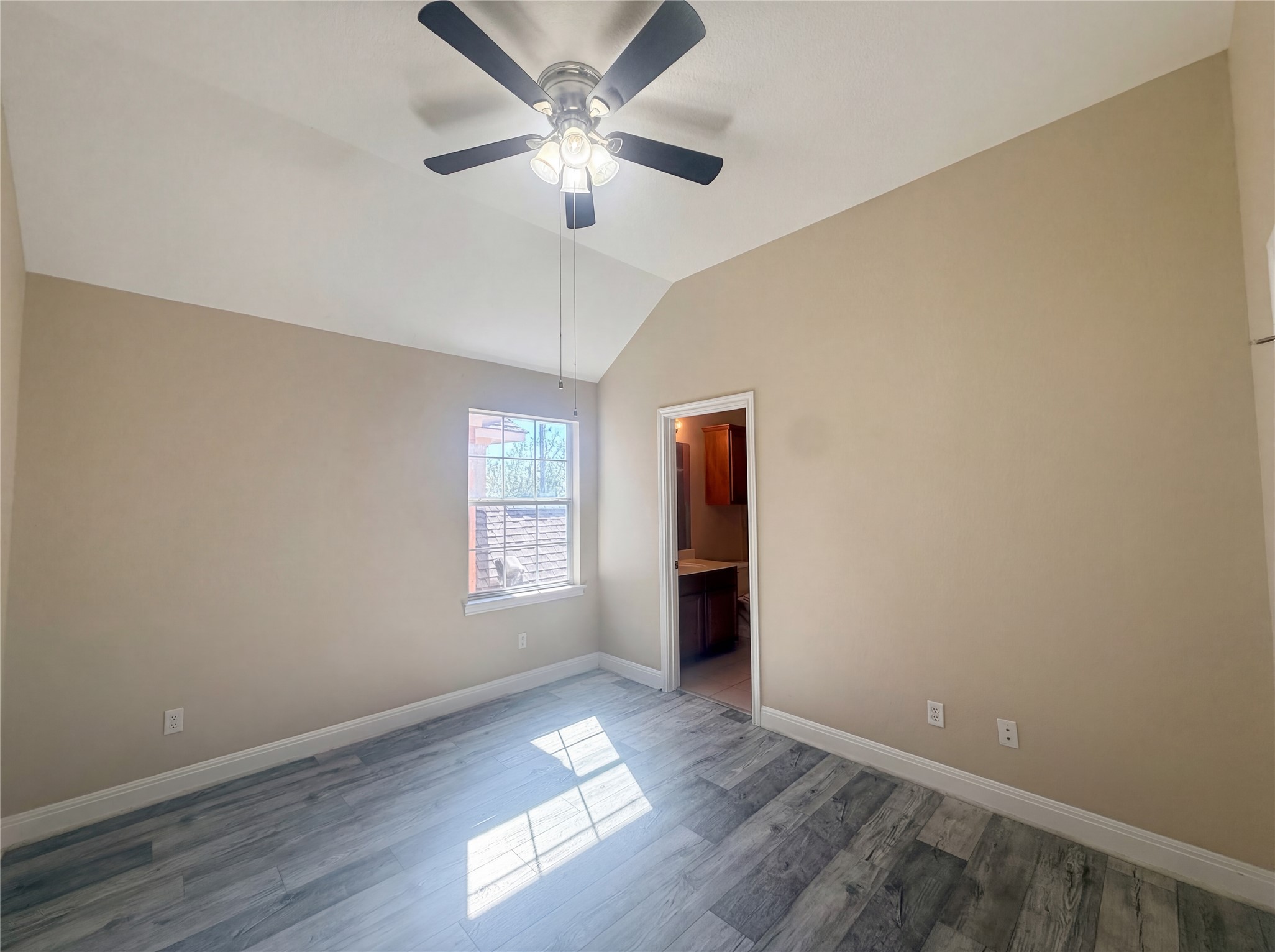 104 Perpetuation Drive Austin, TX 78734 - Photo 19 of 29 Unfurnished bedroom featuring lofted ceiling, ceiling fan, light wood-type flooring, and connected bathroom