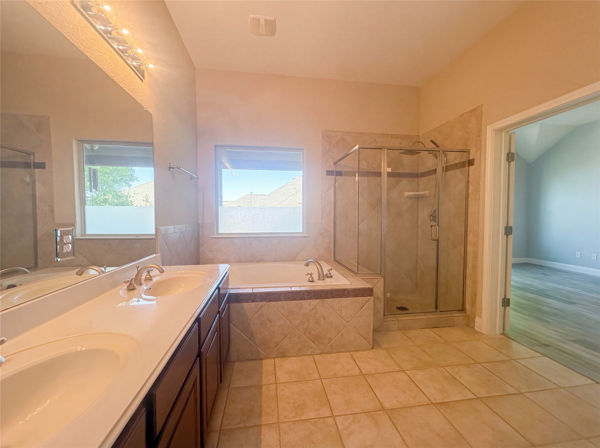 104 Perpetuation Drive Austin, TX 78734 - Photo 23 of 29 Full bathroom with double vanity, a shower stall, a garden tub, and light tile patterned floors