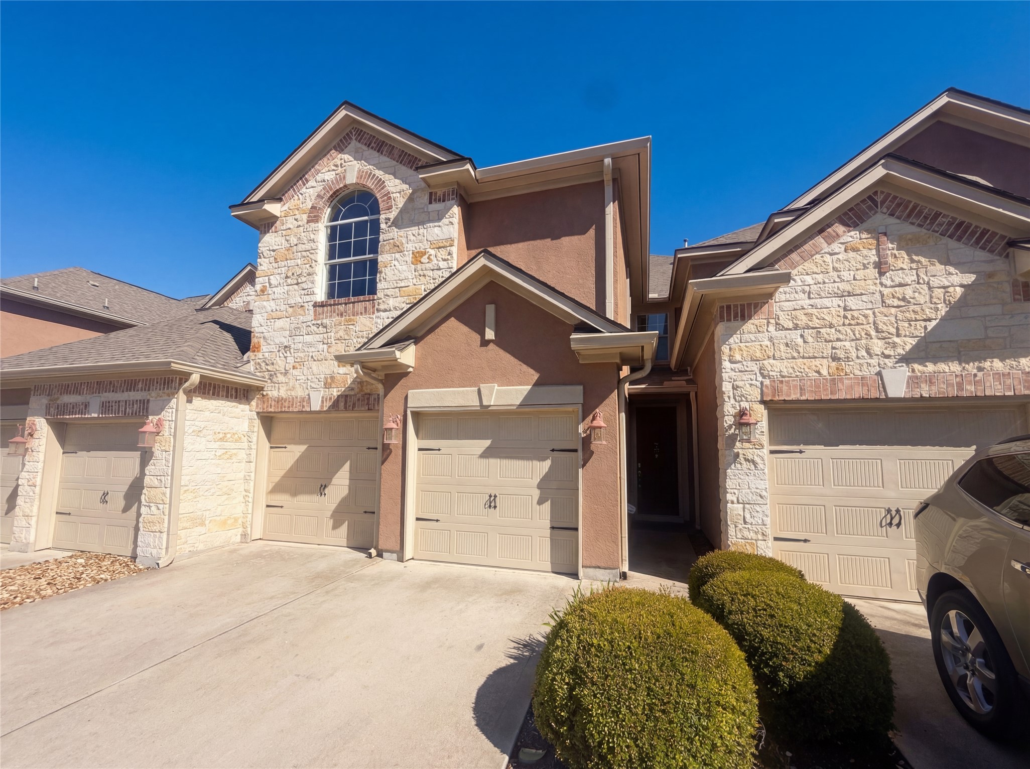 104 Perpetuation Drive Austin, TX 78734 - Photo 25 of 29 View of front of house with stone siding, stucco siding, concrete driveway, and an attached garage