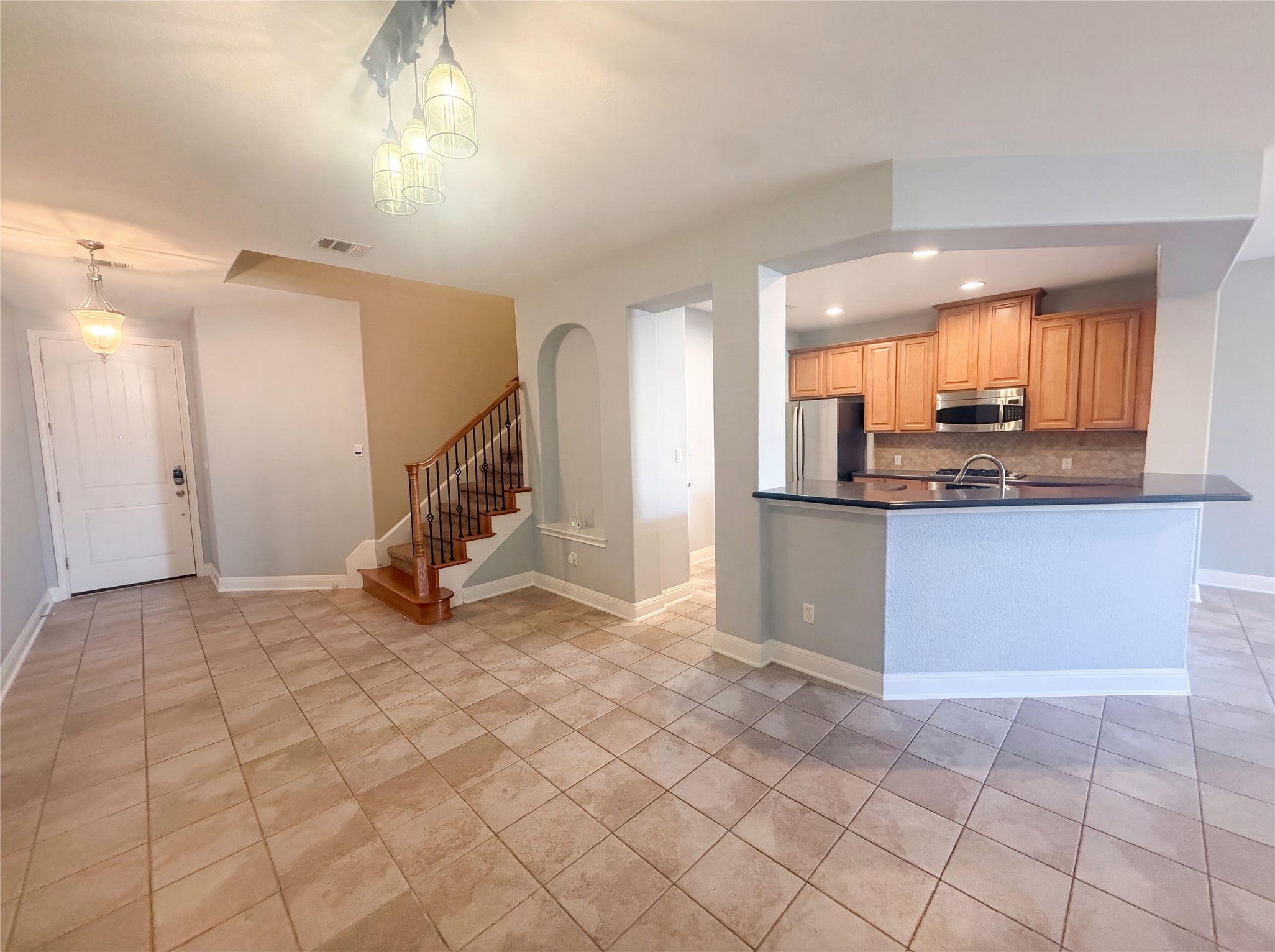 104 Perpetuation Drive Austin, TX 78734 - Photo 7 of 29 Kitchen with dark countertops, stainless steel appliances, light tile patterned floors, and pendant lighting