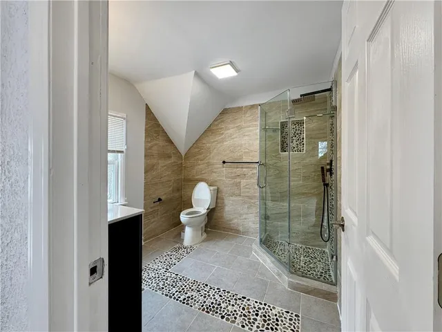 a bathroom with a toilet and a shower
