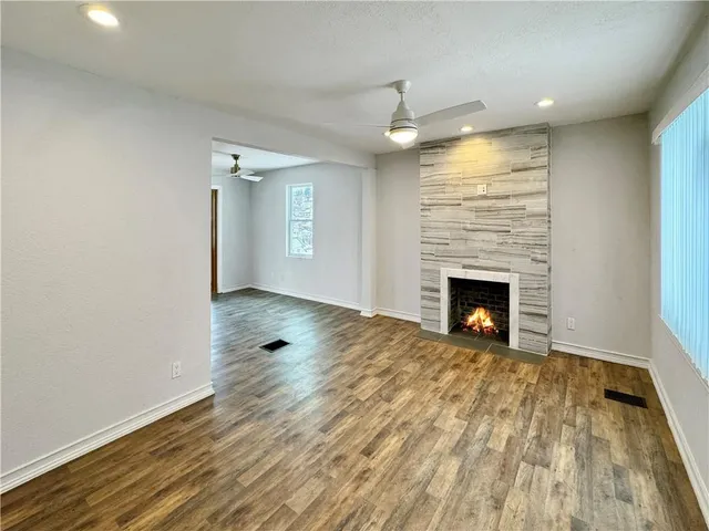 an empty room with wooden floor and fireplace