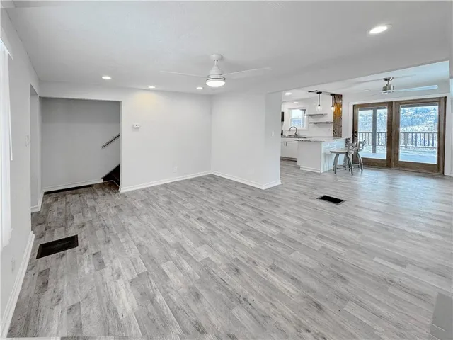a view of empty room with wooden floor and windows