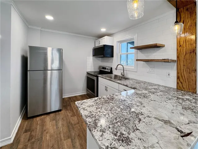 a kitchen with kitchen island a sink stainless steel appliances and refrigerator