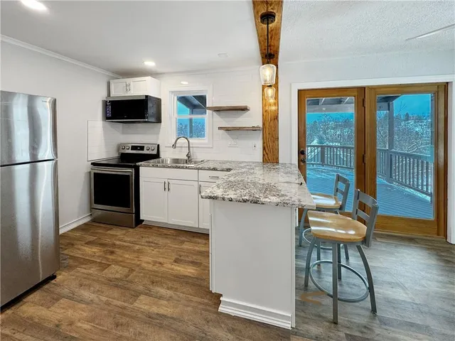 a kitchen with stainless steel appliances granite countertop a refrigerator and a stove top oven