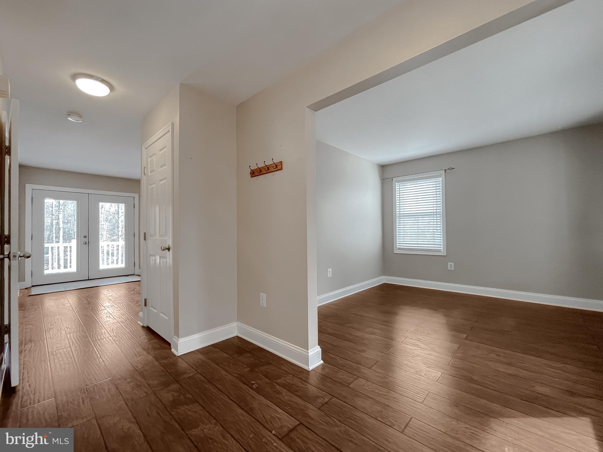12968 Sailboat Lane Lusby, MD 20657 - Photo 15 of 57 an empty room with wooden floor and windows