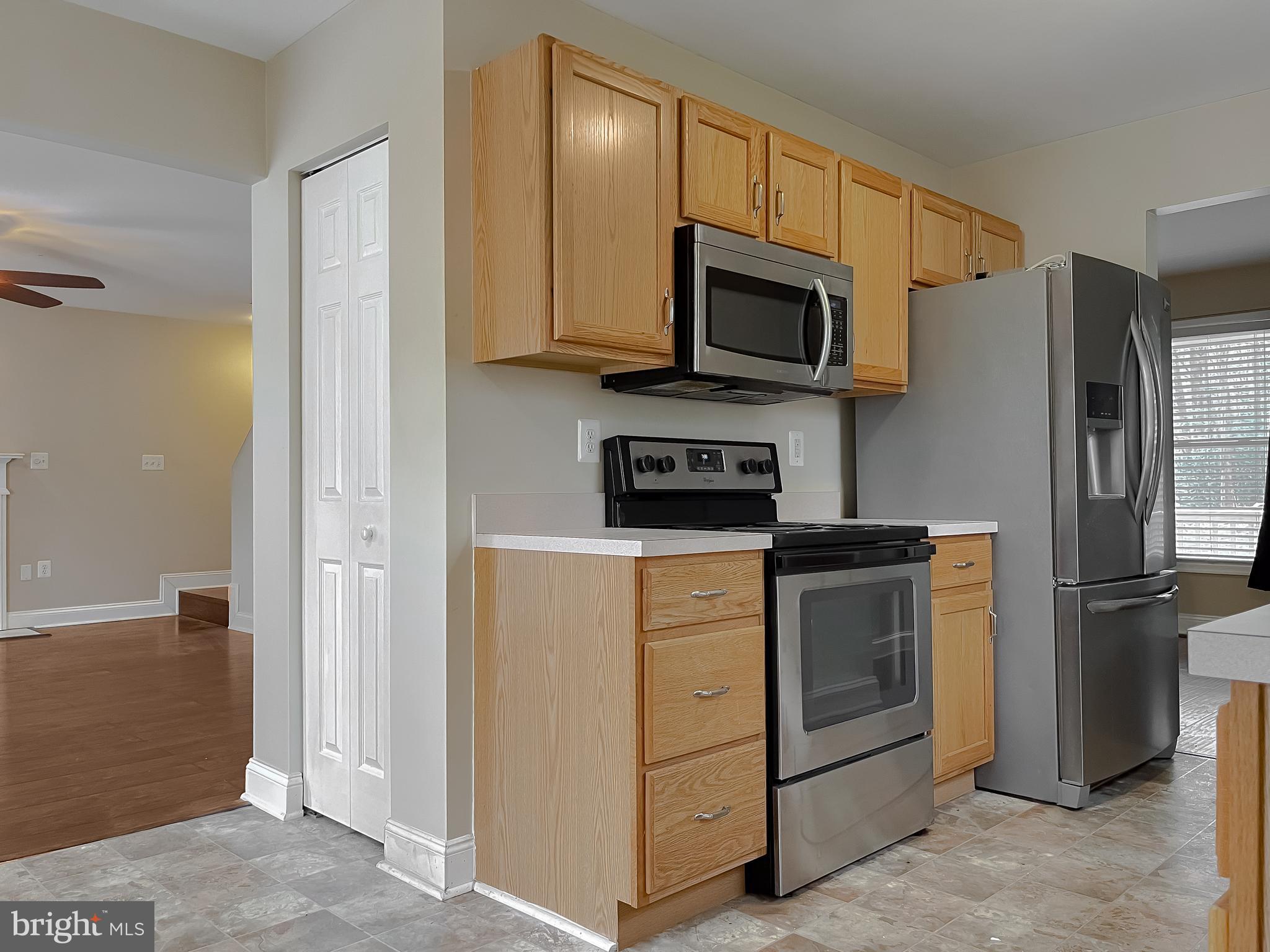 12968 Sailboat Lane Lusby, MD 20657 - Photo 18 of 57 a kitchen with stainless steel appliances granite countertop white cabinets a refrigerator and a sink