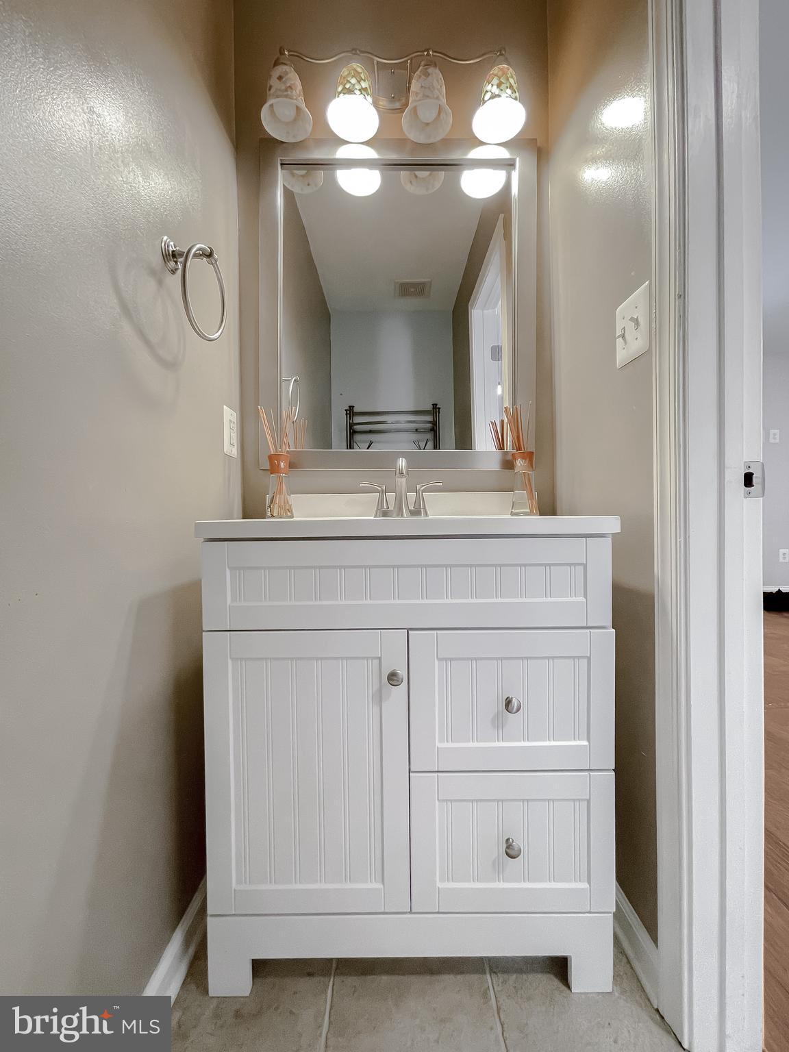 12968 Sailboat Lane Lusby, MD 20657 - Photo 22 of 57 a bathroom with a sink vanity and a mirror