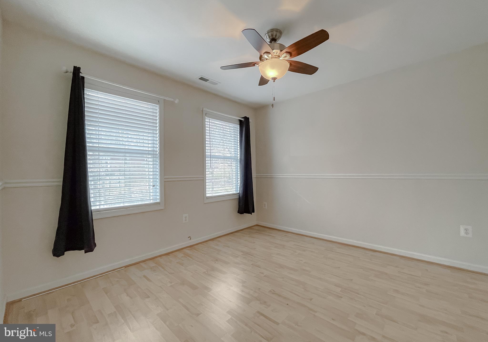 12968 Sailboat Lane Lusby, MD 20657 - Photo 30 of 57 an empty room with windows and chandelier fan