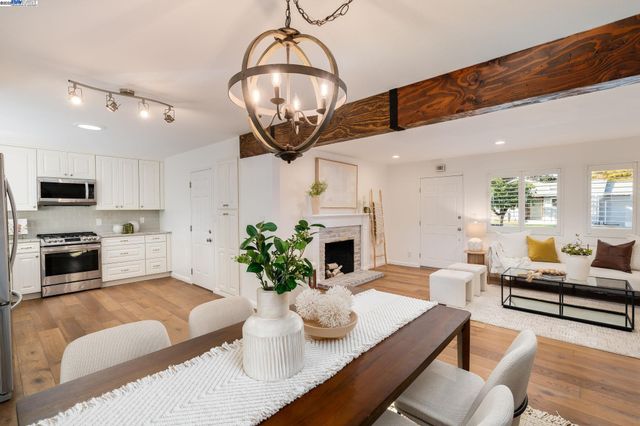 a living room with furniture kitchen and a chandelier