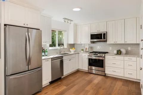 a kitchen with stainless steel appliances a refrigerator sink and microwave