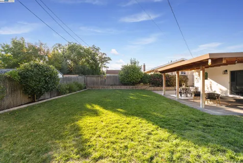 a view of a house with backyard and sitting area