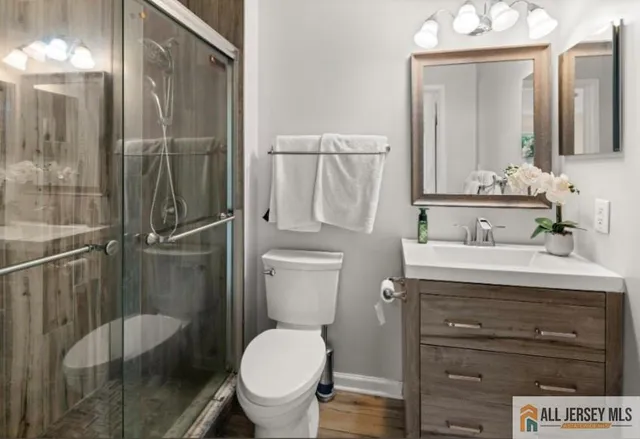 a bathroom with a granite countertop sink toilet a mirror and shower