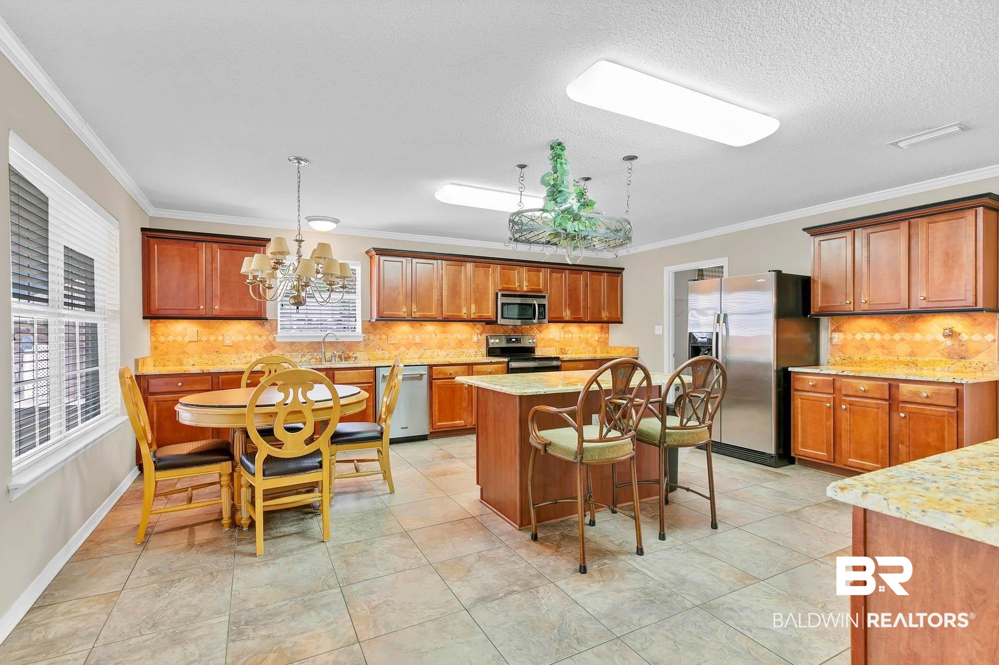 329 Collinwood Loop Foley, AL 36535 - Photo 10 of 35 Kitchen with appliances with stainless steel finishes, a sink, crown molding, tasteful backsplash, and a kitchen island