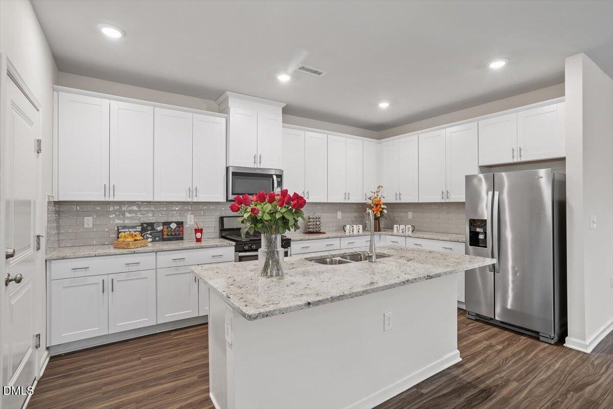 46 Coffee Tree Circle Clayton, NC 27527 - Photo 10 of 36 a kitchen with stainless steel appliances granite countertop a sink refrigerator and cabinets
