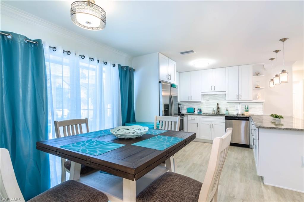 28 Constitution Drive Naples, FL 34112 - Photo 12 of 30 a kitchen with a table chairs and wooden floor