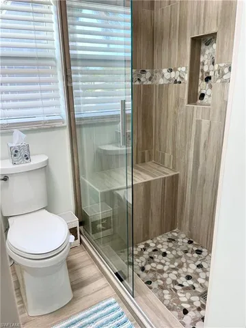 a bathroom with a granite countertop sink a toilet and a mirror