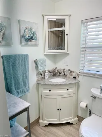 a bathroom with a granite countertop sink toilet and shower