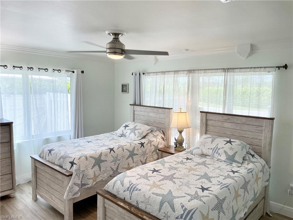 28 Constitution Drive Naples, FL 34112 - Photo 30 of 30 a bedroom with two beds and a chandelier