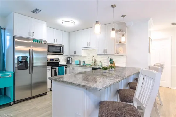a kitchen with stainless steel appliances granite countertop a sink refrigerator and microwave