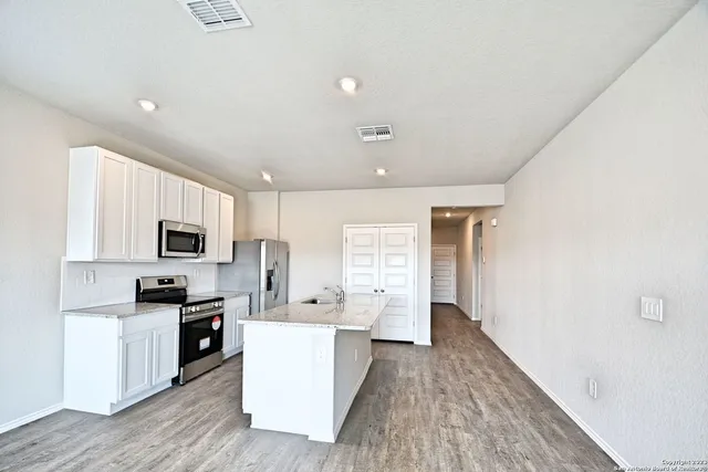 a kitchen with stainless steel appliances a refrigerator sink and cabinets