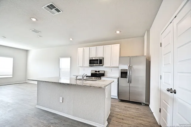 a kitchen with a refrigerator a sink and cabinets