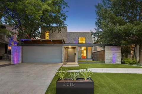 a front view of house with yard and trees in the background