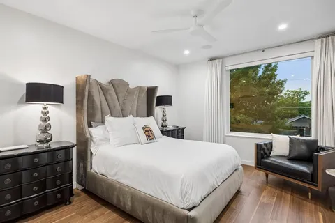 a bedroom with a bed and a large window