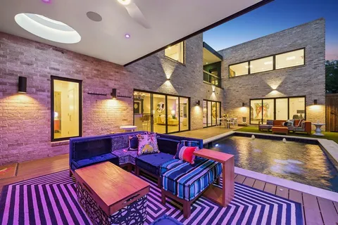 a living room with furniture pool table wooden floor and a fireplace